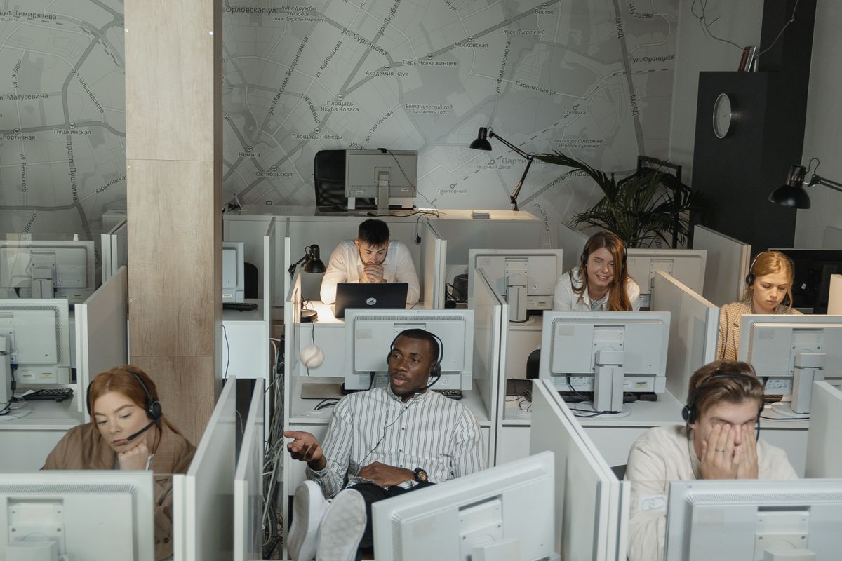 Professional call center team working at computers with headsets